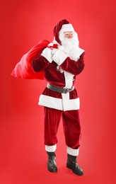 Photo of Santa Claus with sack on red background