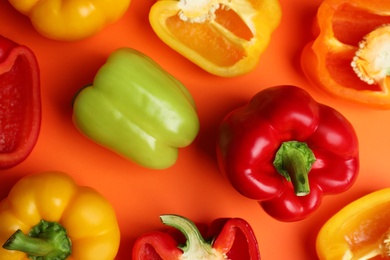 Flat lay composition with ripe bell peppers on orange background