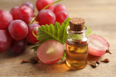 Bottle of natural grape seed oil on wooden table. Organic cosmetic