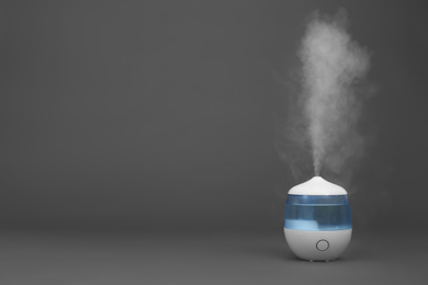 Modern air humidifier on grey background. Space for text