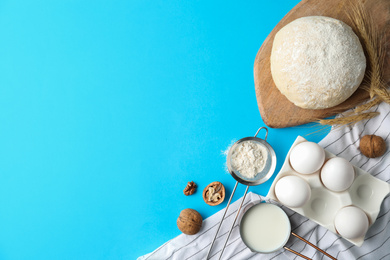 Photo of Flat lay composition with dough on blue background, space for text. Cooking pastries