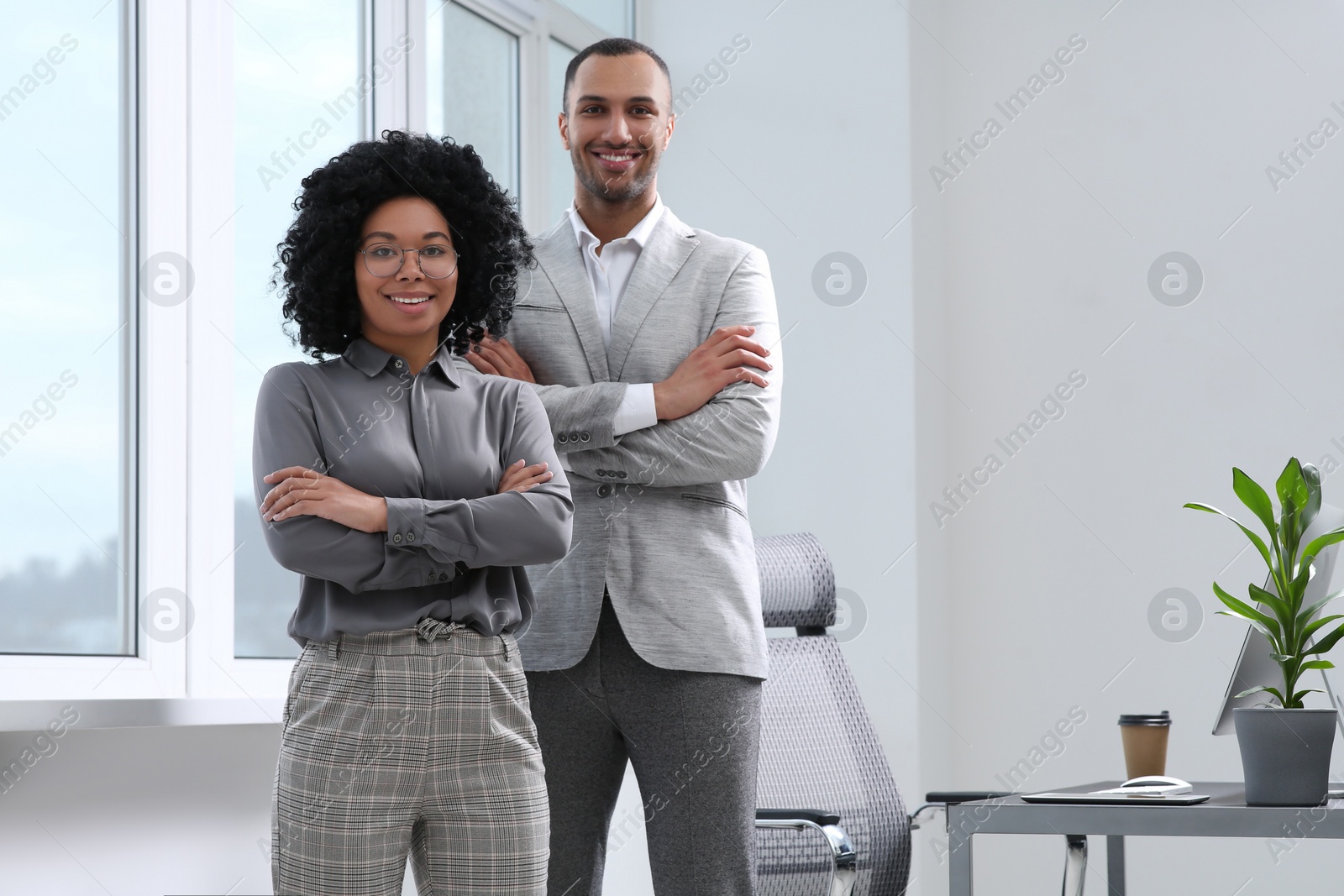 Photo of Young smiling colleagues near window in modern office