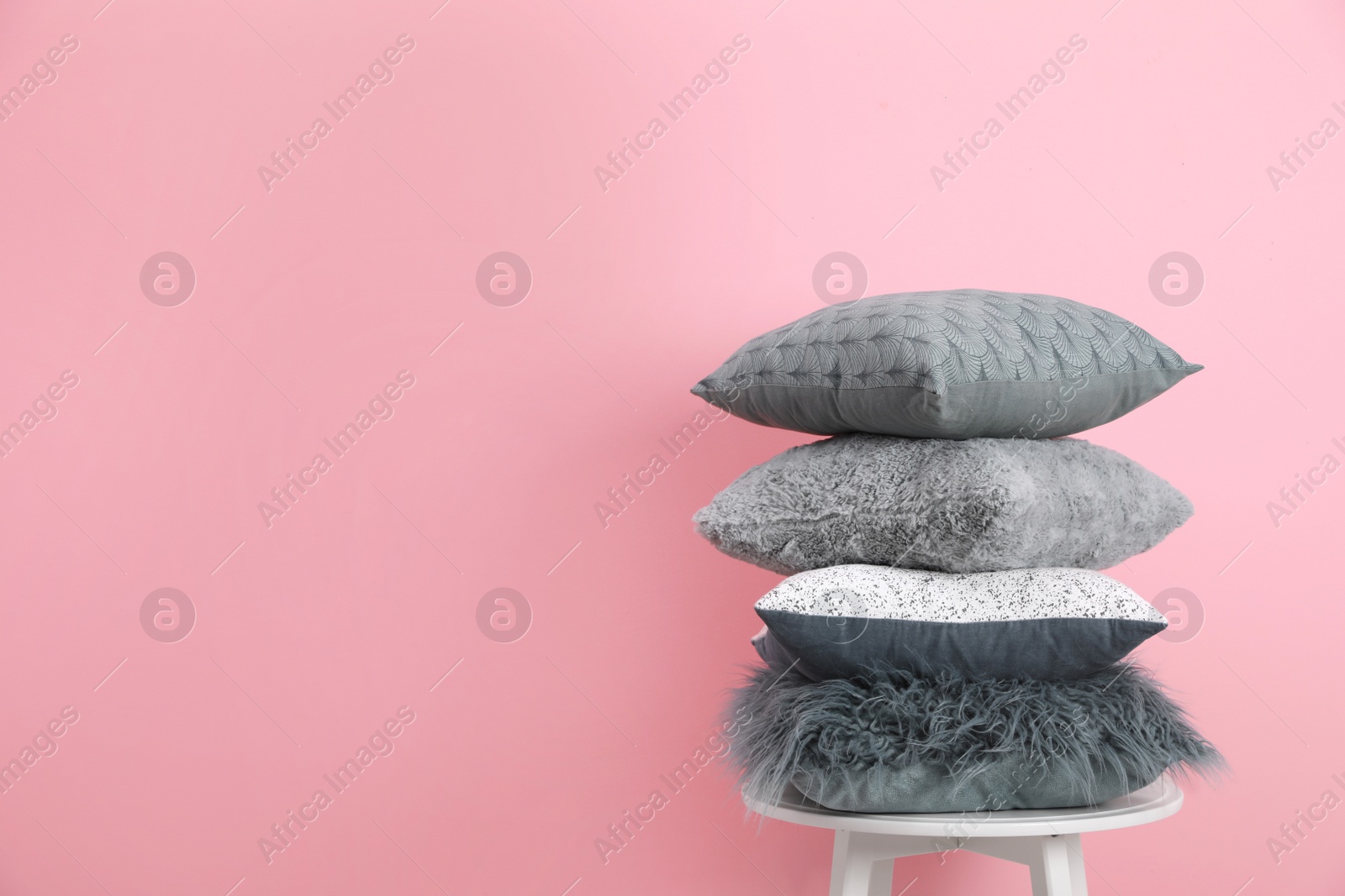 Photo of Chair with many different pillows and space for text on color background