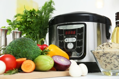 Photo of Modern multi cooker and products on table
