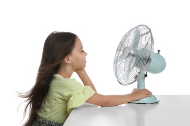 Photo of Little girl enjoying air flow from fan on white background. Summer heat