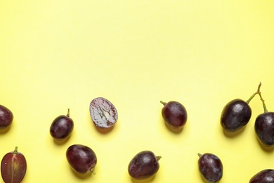Photo of Flat lay composition with fresh ripe juicy grapes on yellow background, space for text