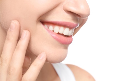 Young woman with beautiful smile on white background, closeup. Teeth whitening