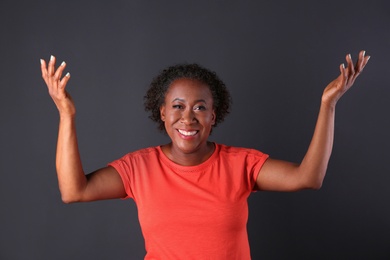 Portrait of happy African-American woman on black background