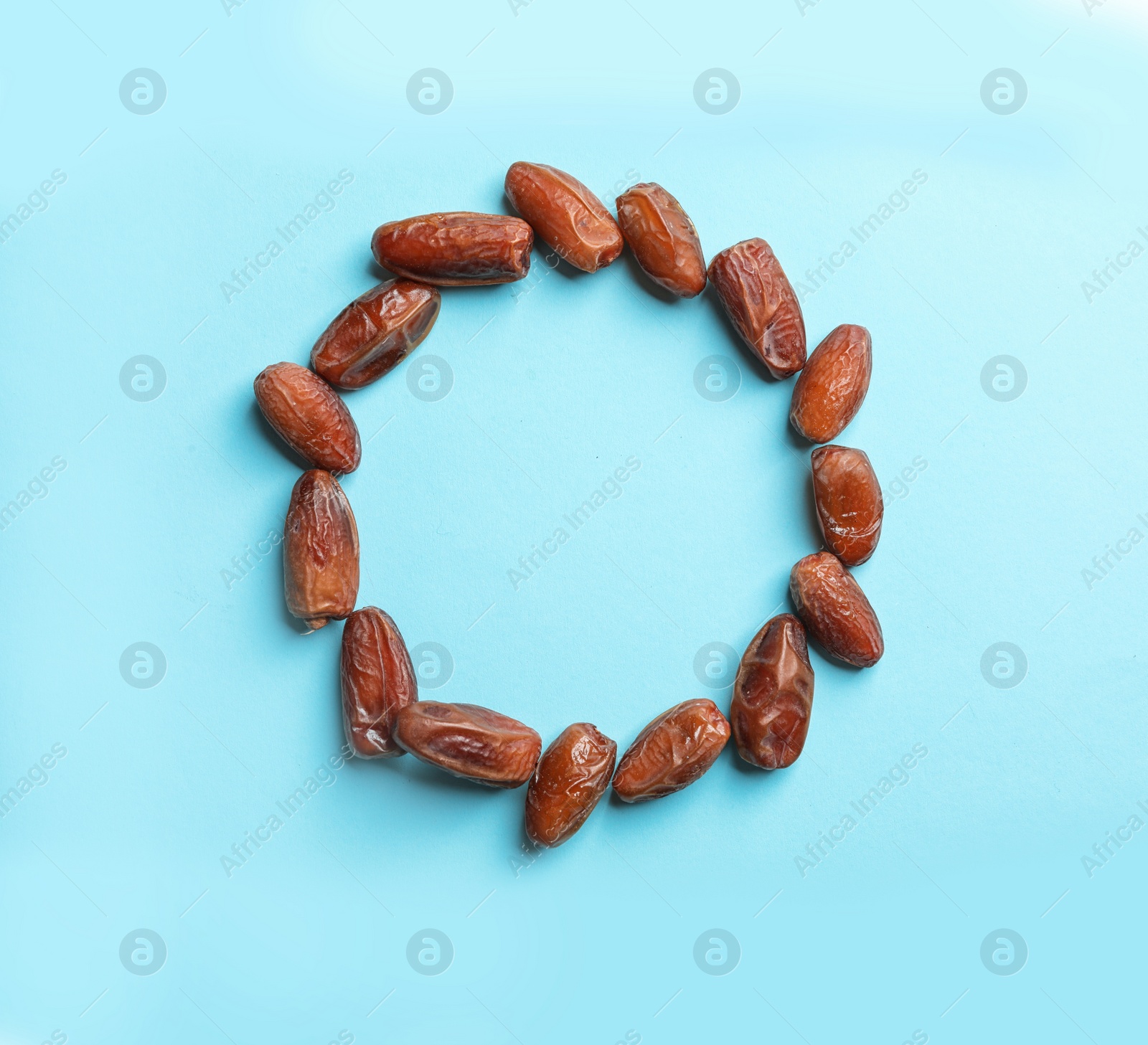 Photo of Frame made of sweet dried date fruits on color background, top view with space for text