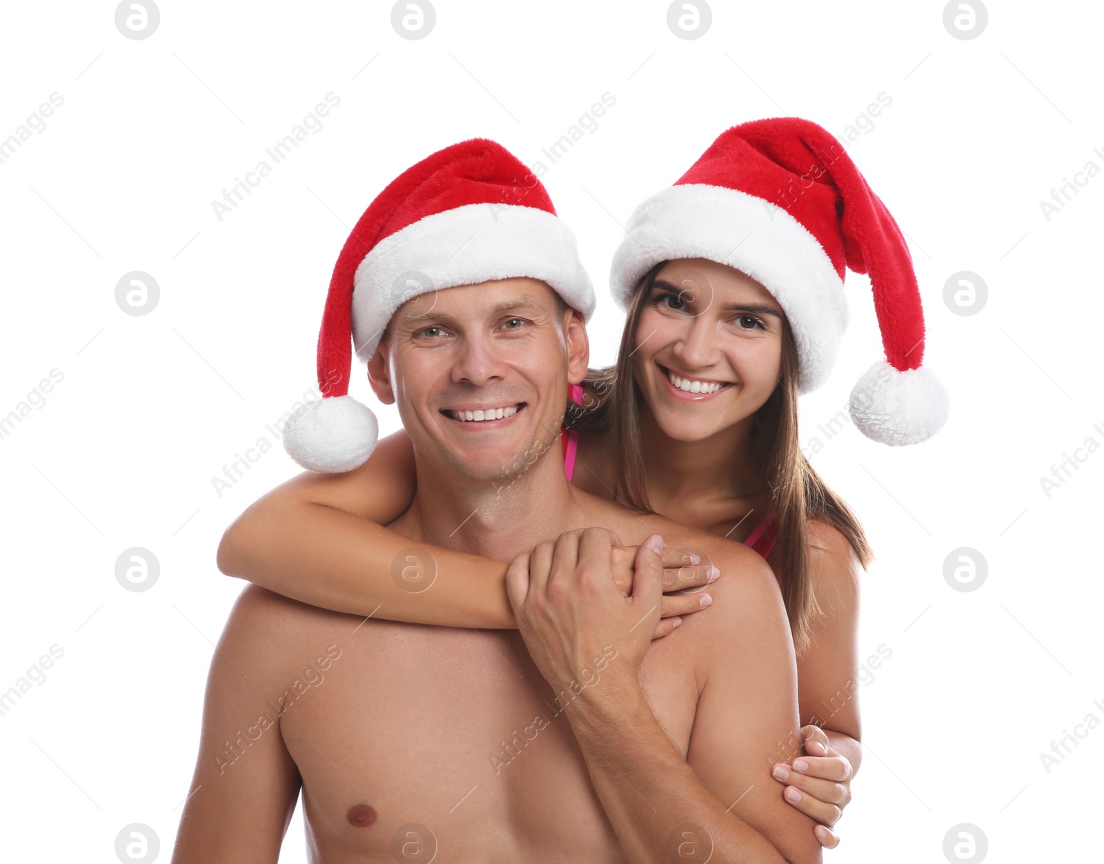 Photo of Happy couple with Santa hats together on white background. Christmas vacation