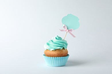 Photo of Delicious birthday cupcake on gray background