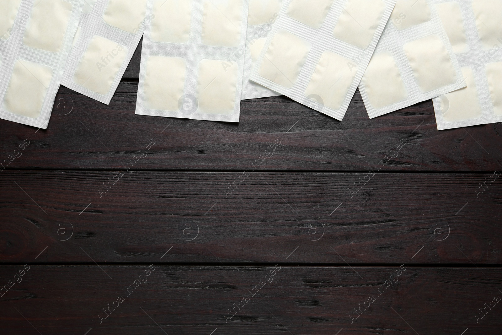 Photo of Mustard plasters on wooden table, flat lay. Space for text