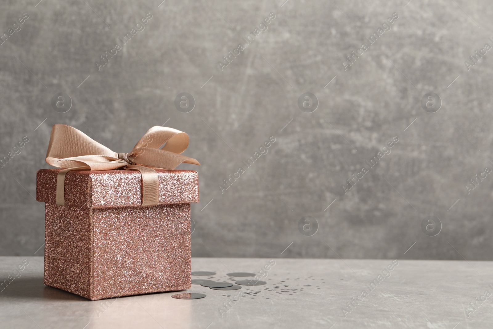 Photo of Beautiful gift box and confetti on white table, space for text