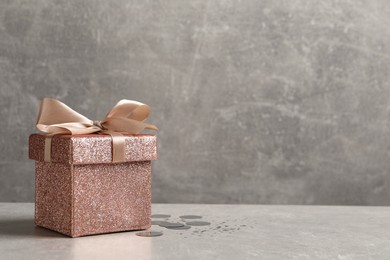 Photo of Beautiful gift box and confetti on white table, space for text