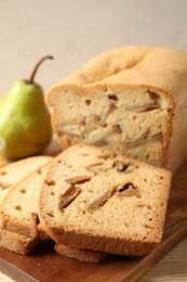 Photo of Tasty pear bread on wooden board, closeup. Homemade cake