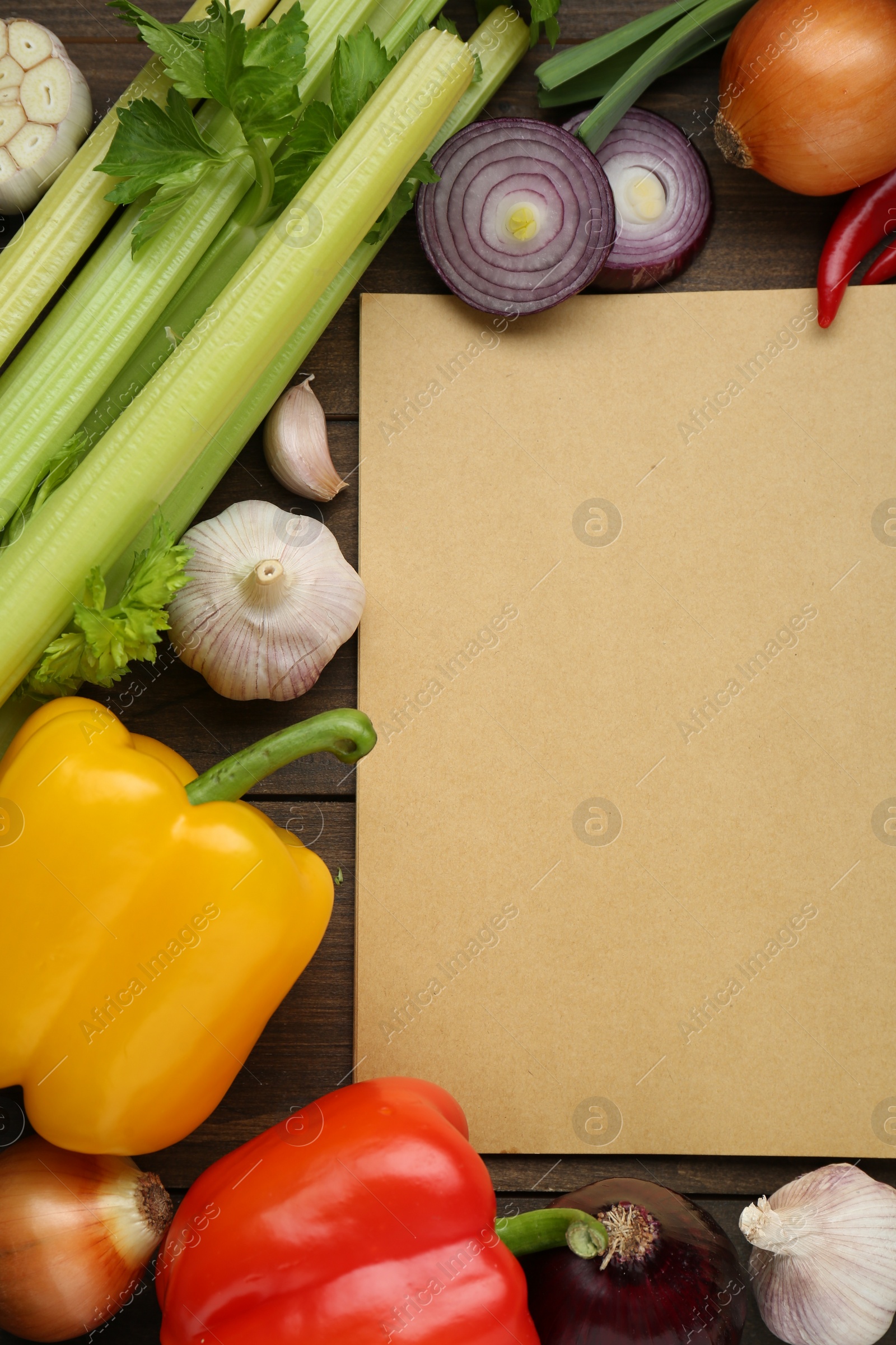 Photo of Blank recipe book and different ingredients on wooden table, flat lay. Space for text