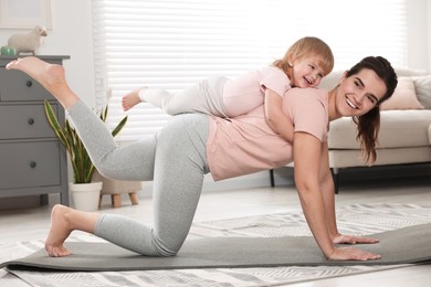 Mother doing exercise with her daughter at home