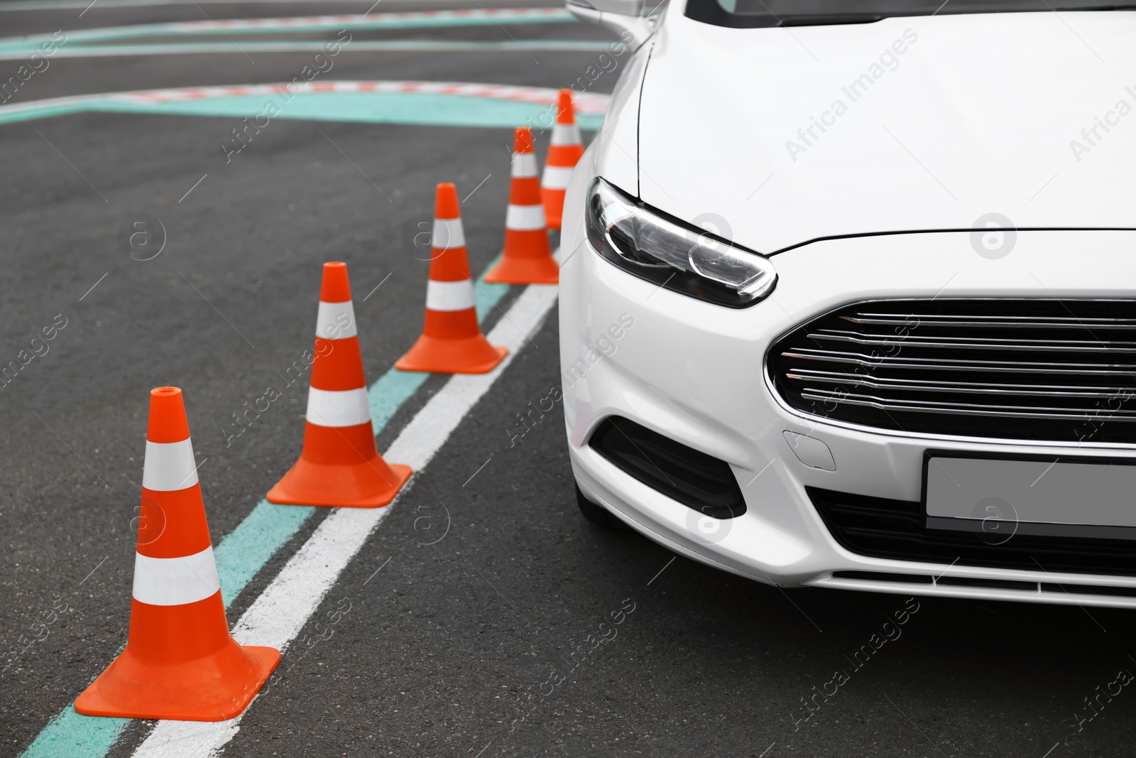 Photo of Modern car on test track with traffic cones, closeup. Driving school