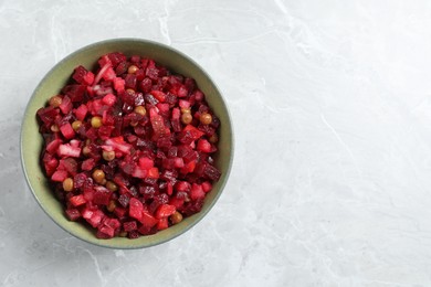 Bowl of delicious fresh vinaigrette salad on light grey marble table, top view. Space for text