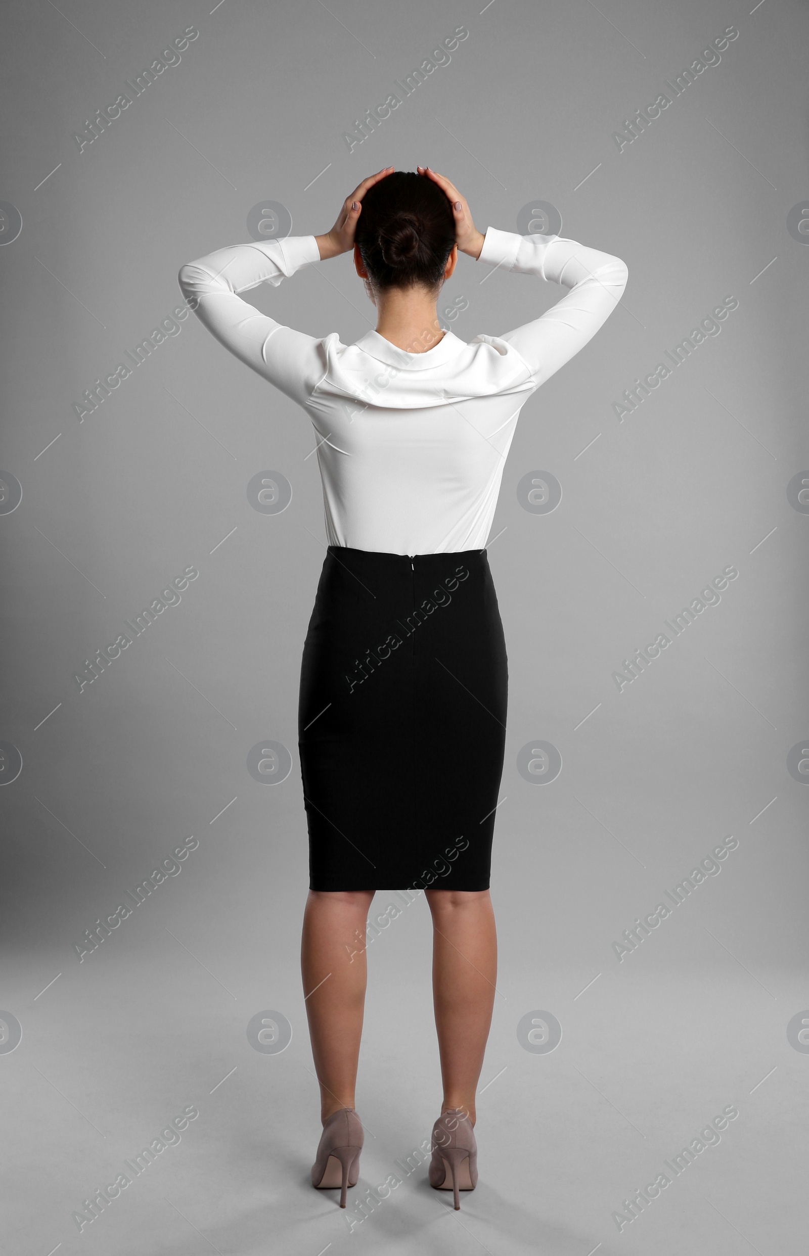 Photo of Young businesswoman in elegant suit on grey background, back view