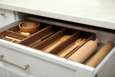 Open drawer of kitchen cabinet with different utensils, closeup