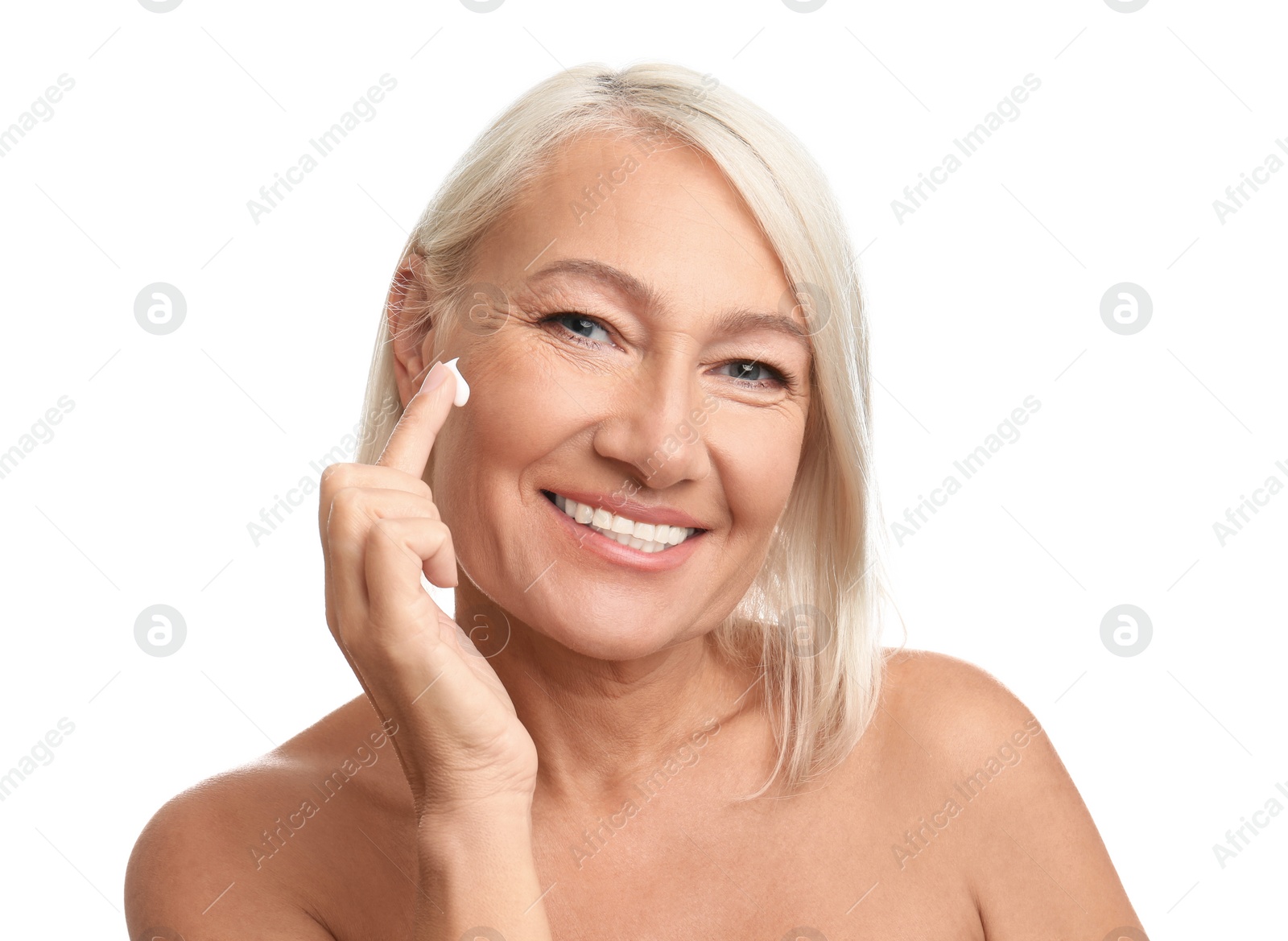 Photo of Mature woman applying face cream on white background