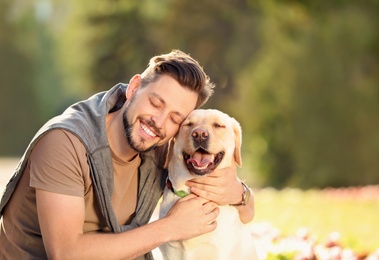 Photo of Cute yellow labrador retriever with owner outdoors