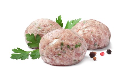 Photo of Three fresh raw meatballs with parsley and spices on white background