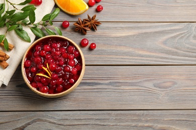 Flat lay composition with cranberry sauce on wooden table, space for text