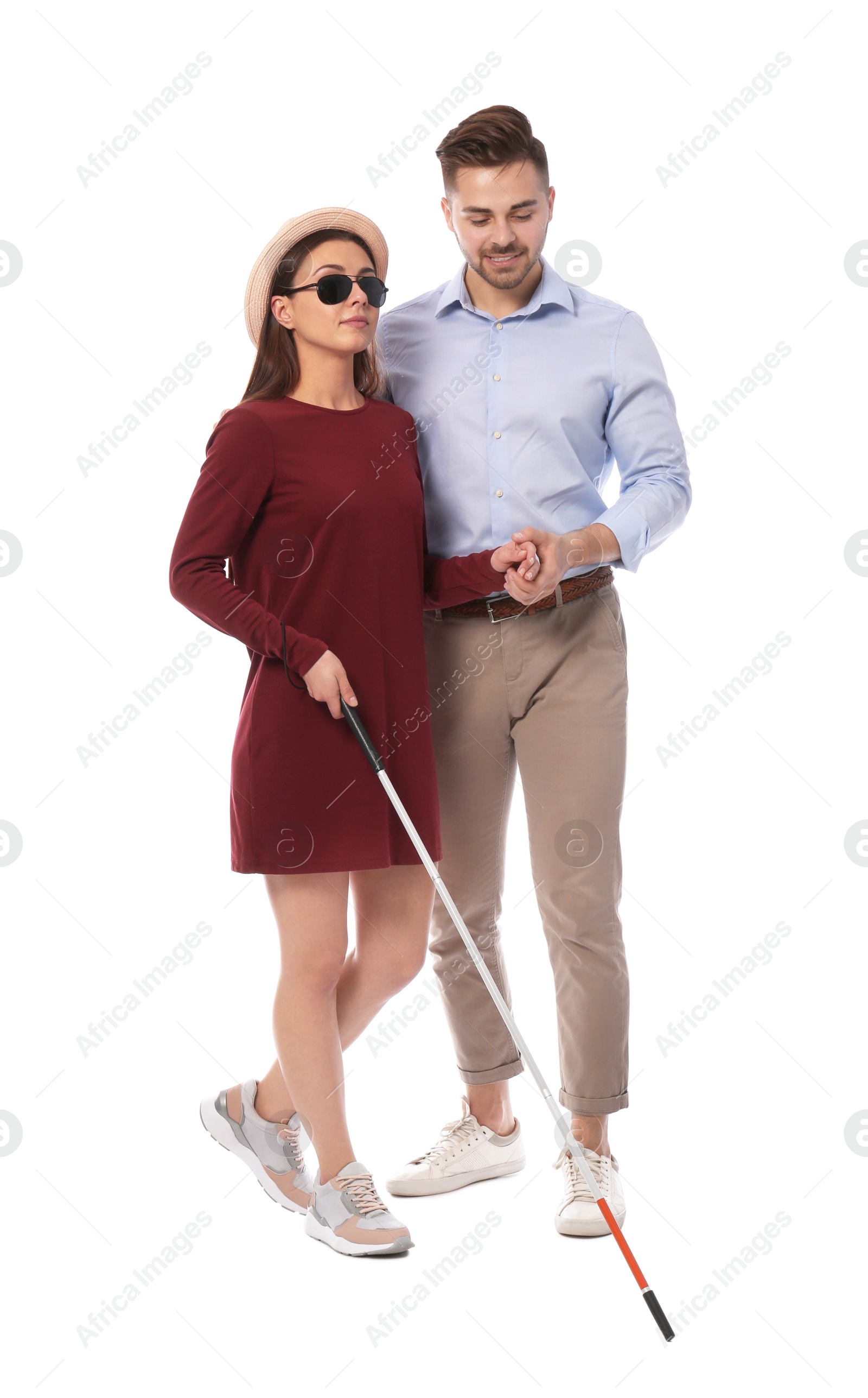 Photo of Young man helping blind person with long cane on white background