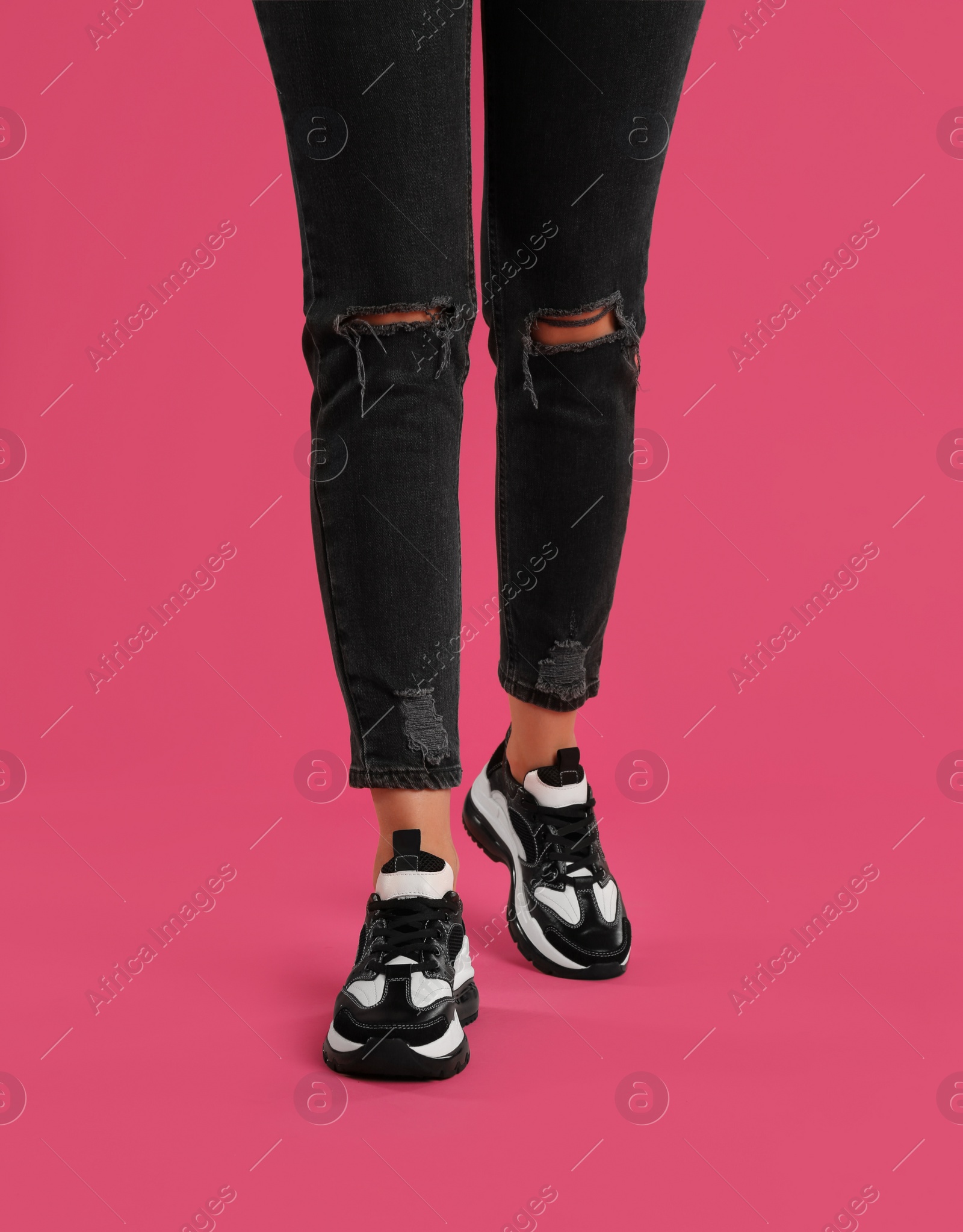 Photo of Woman wearing sneakers on pink background, closeup