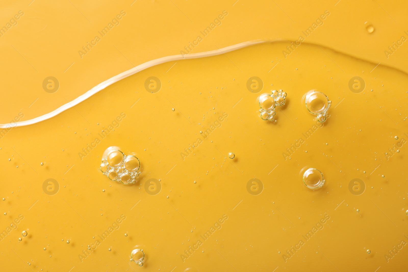 Photo of Sample of hydrophilic oil on orange background, top view