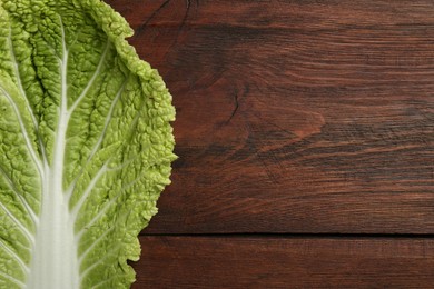 Photo of Fresh leaf of Chinese cabbage on wooden table, top view. Space for text