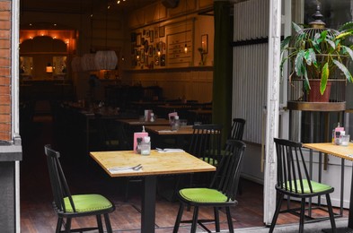 Entrance of cafe with chairs and tables outdoors