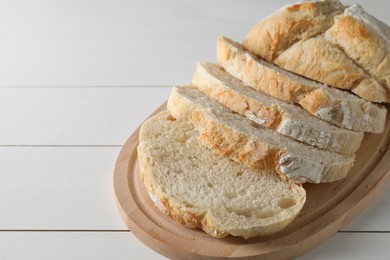 Photo of Freshly baked cut sourdough bread on white wooden table. Space for text