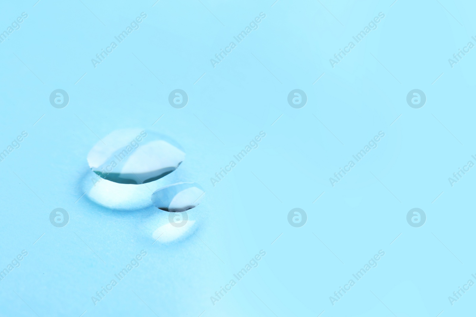 Photo of Pure water drops on color background, closeup. Space for text