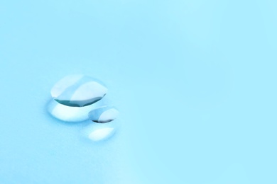 Pure water drops on color background, closeup. Space for text