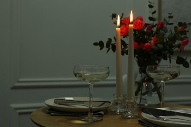 Photo of Romantic table setting with candles and flowers, space for text