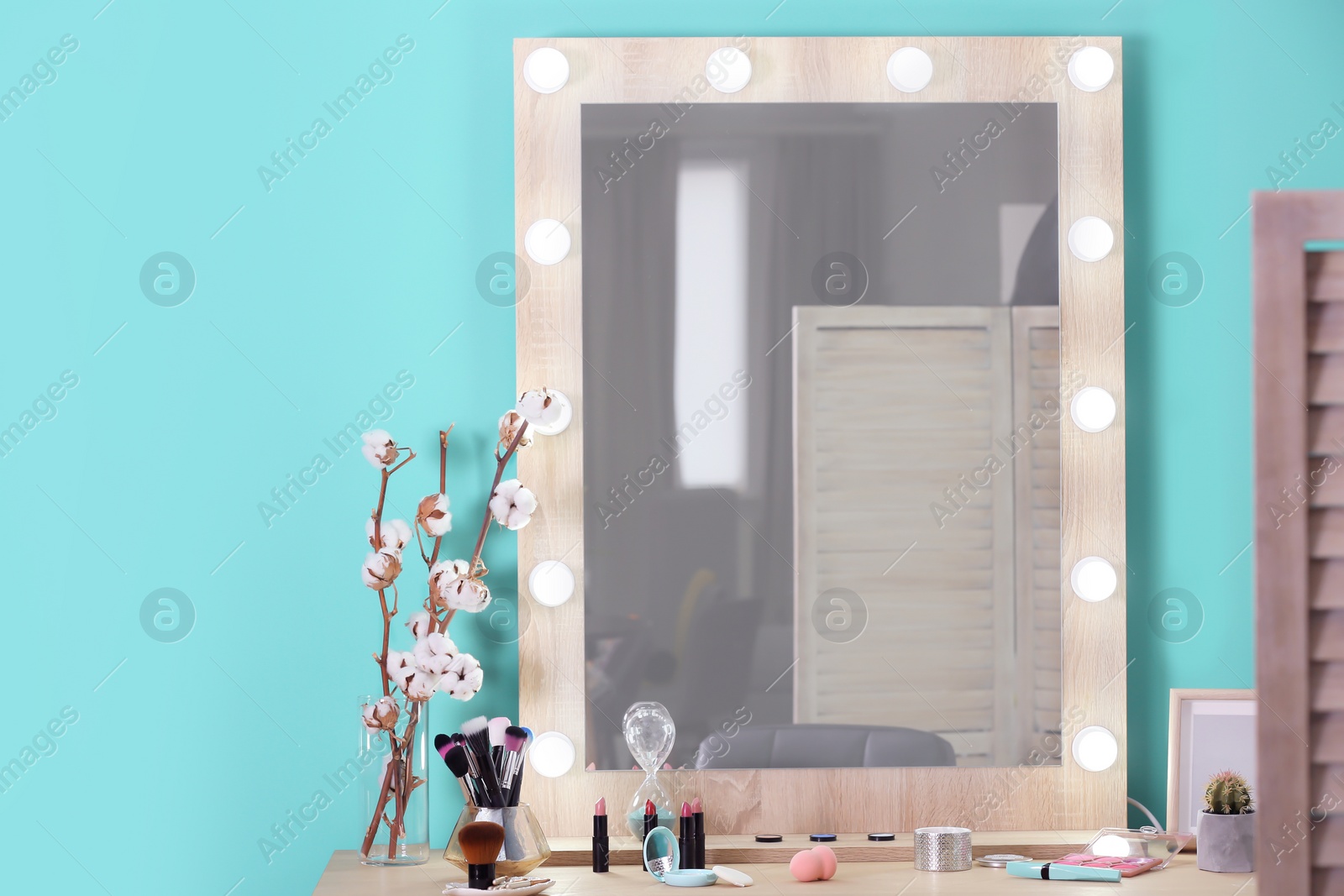 Photo of Decorative cosmetics and tools on dressing table near mirror in makeup room