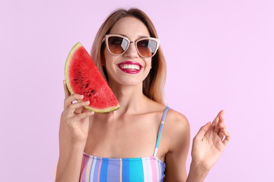 Pretty young woman with juicy watermelon on color background