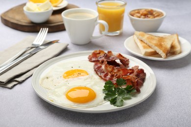 Photo of Delicious breakfast with sunny side up eggs served on light table