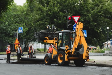 Image of MYKOLAIV, UKRAINE - AUGUST 05, 2021: Workers laying new asphalt on city street. Road repair service