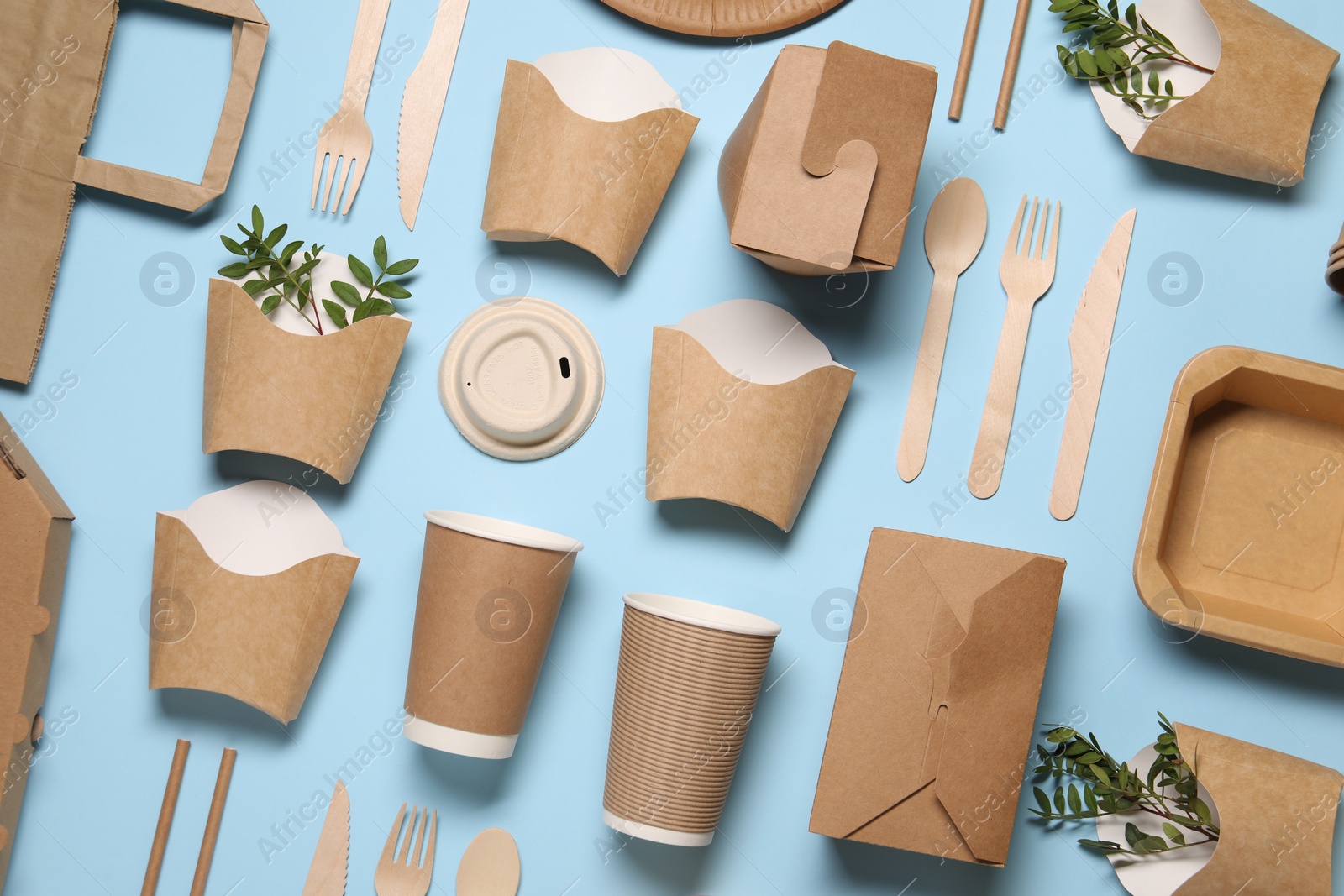 Photo of Flat lay composition with eco friendly food packagings and twigs on light blue background