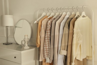 Photo of Modern dressing room interior with rack of stylish clothes