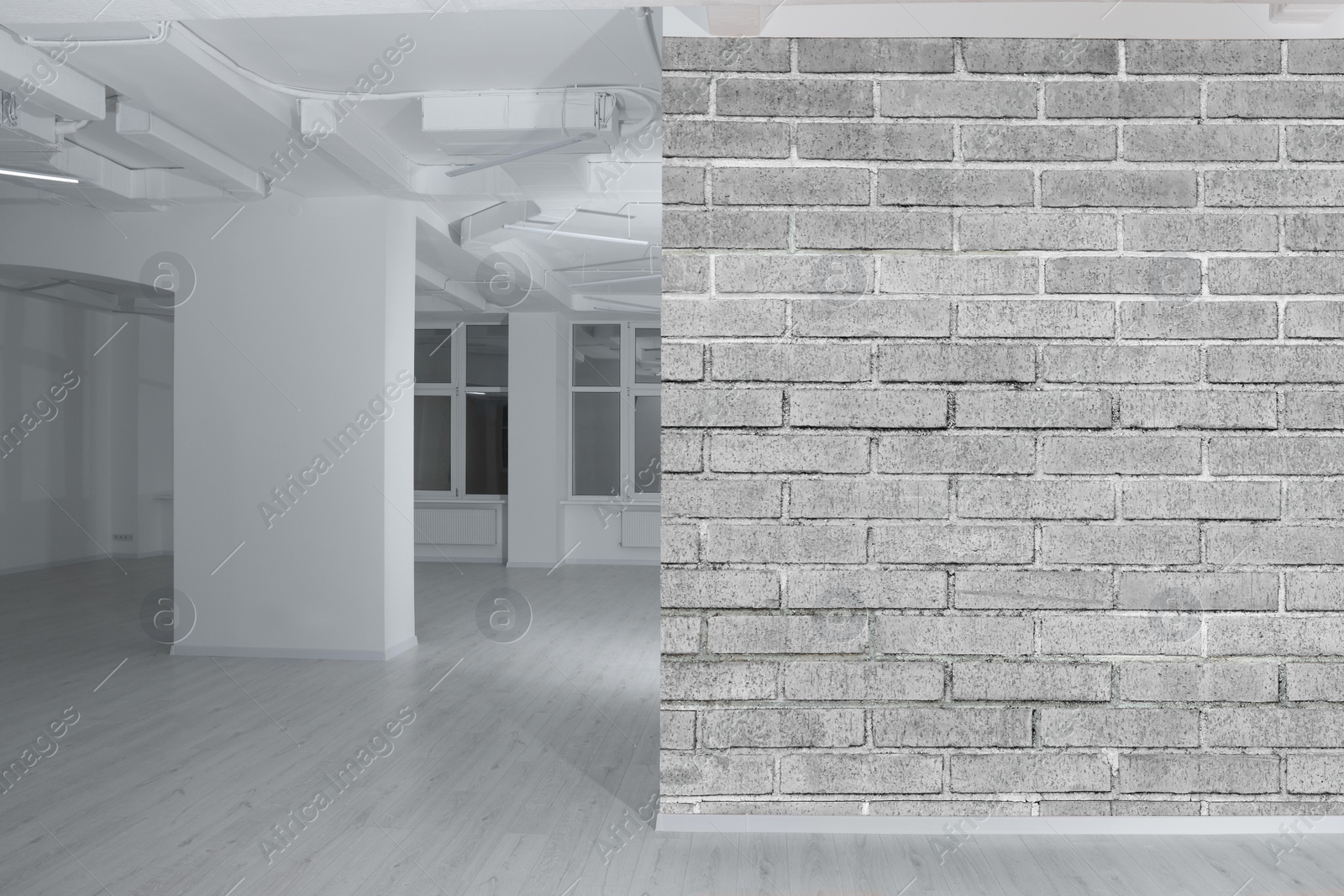 Image of Spacious room with brick wall and wooden floor