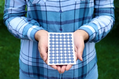 Photo of Woman holding solar panel outdoors, closeup view
