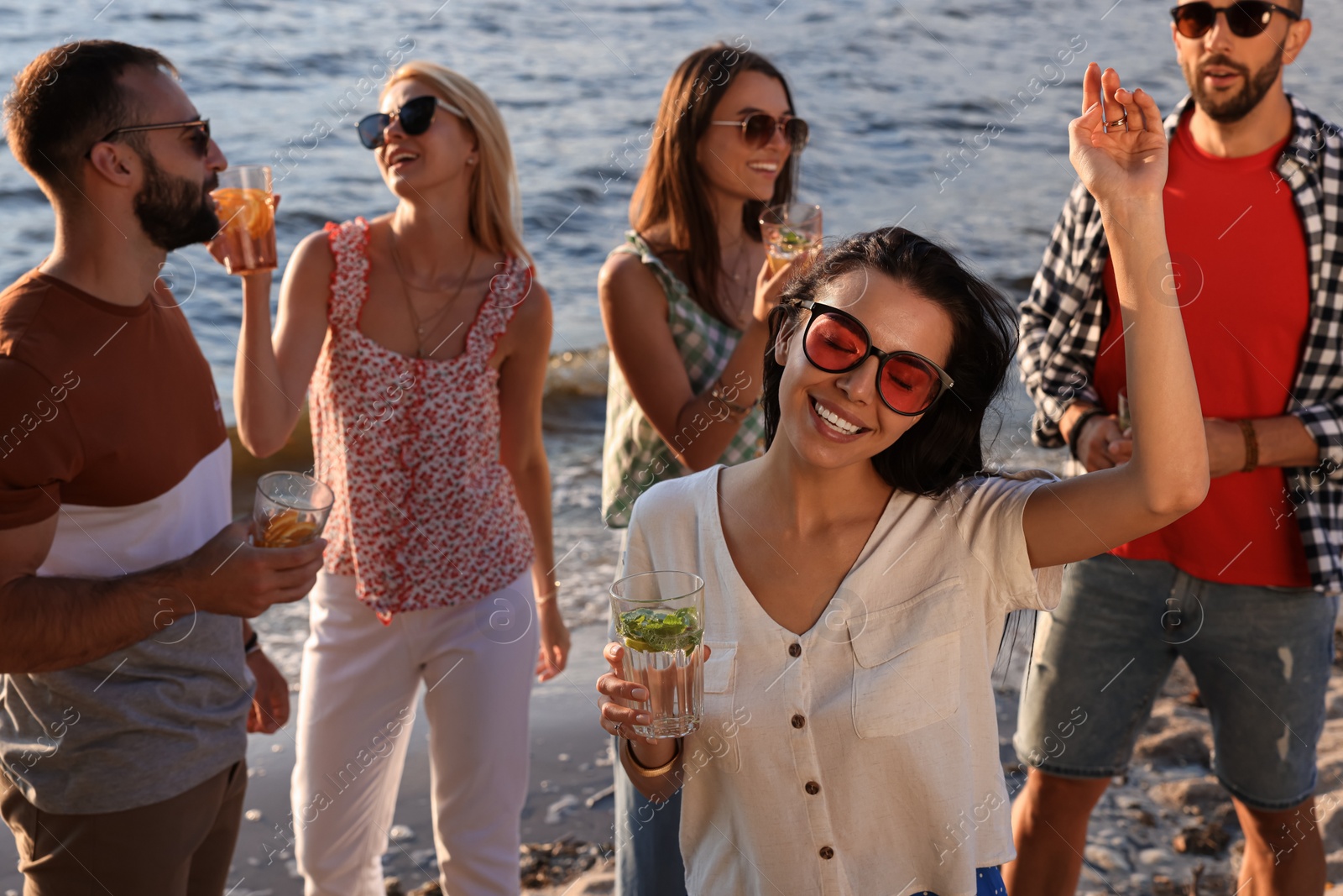 Photo of Woman with friends having fun near river at summer party