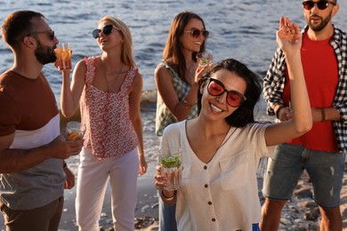 Photo of Woman with friends having fun near river at summer party