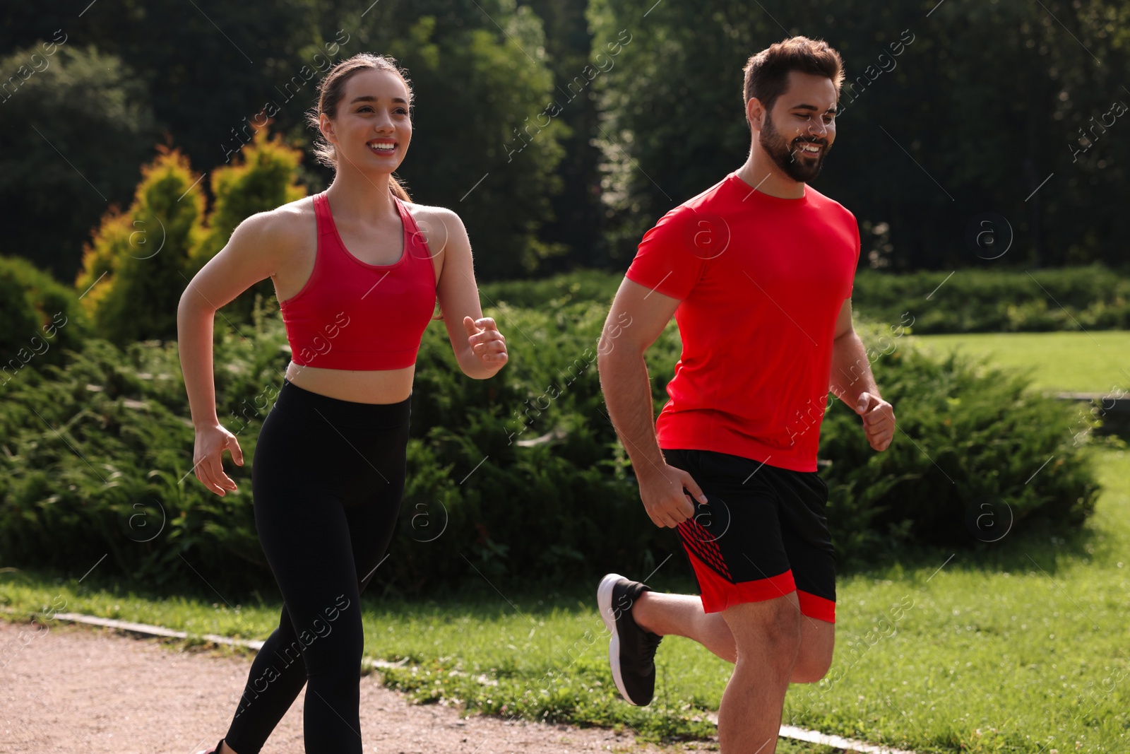 Photo of Healthy lifestyle. Happy couple running in park on sunny day