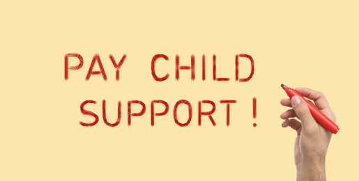 Man with marker and phrase PAY CHILD SUPPORT! on beige background, closeup. Banner design